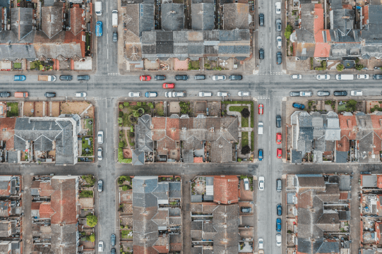 Aerial View of Street Grid with homes, businesses, and vehicles.